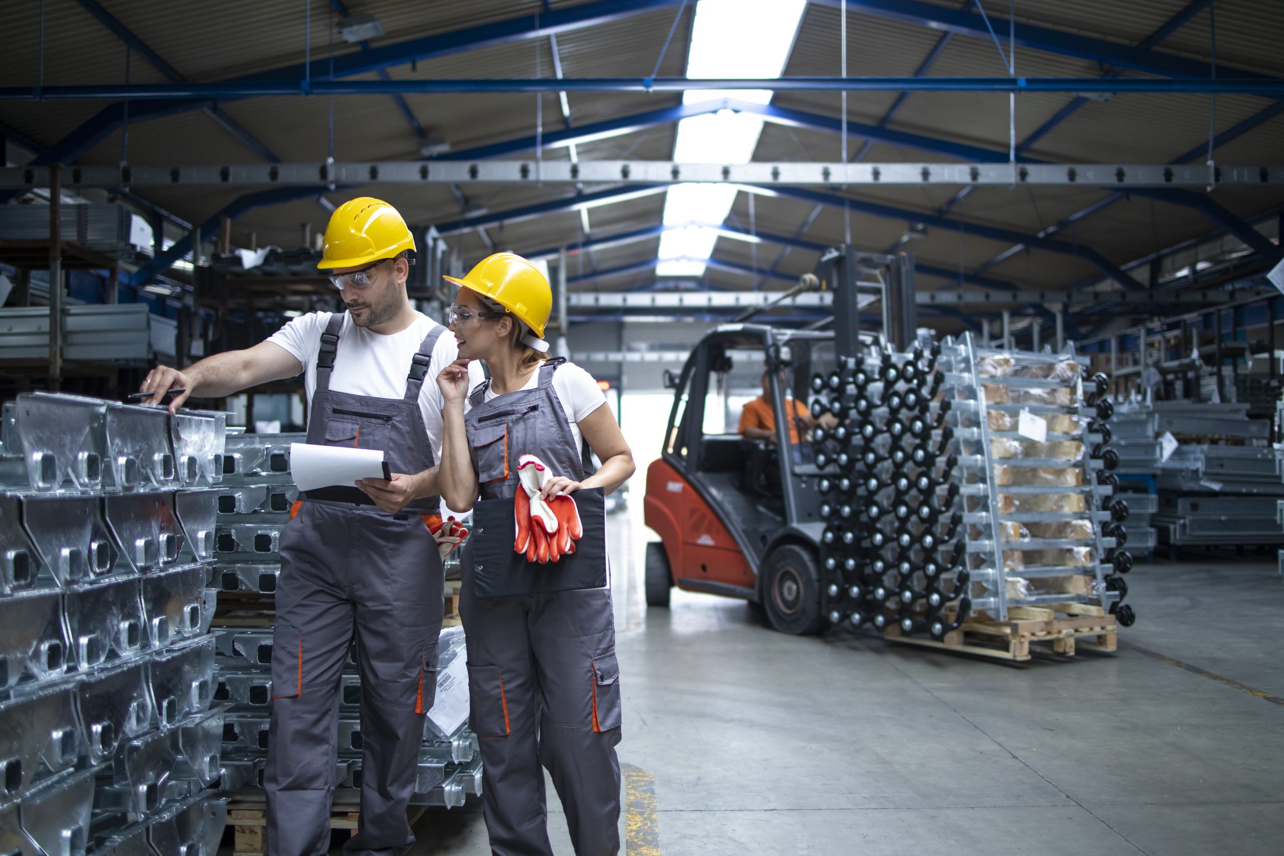 Factory workers checking quality of products in industrial warehouse.